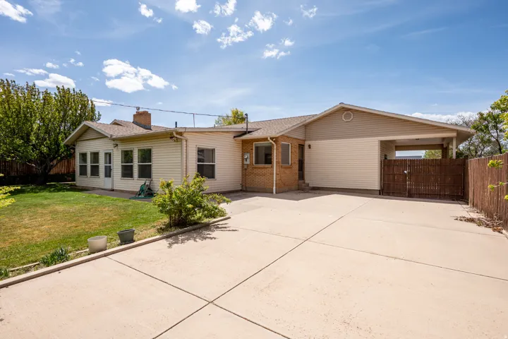 View of front facade featuring a fenced backyard, brick siding, a patio area, and a shingled roof
