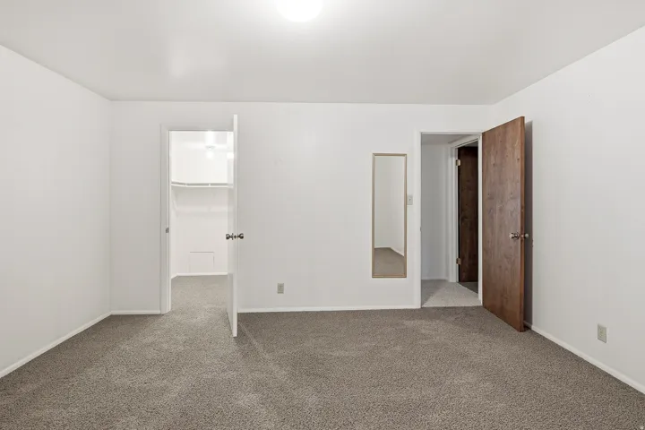 Unfurnished bedroom featuring a spacious closet and carpet floors