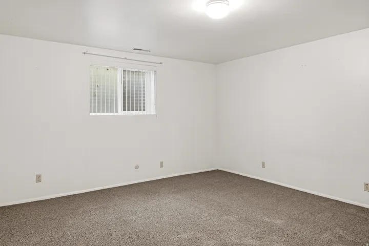 Spare room with dark carpet and baseboards