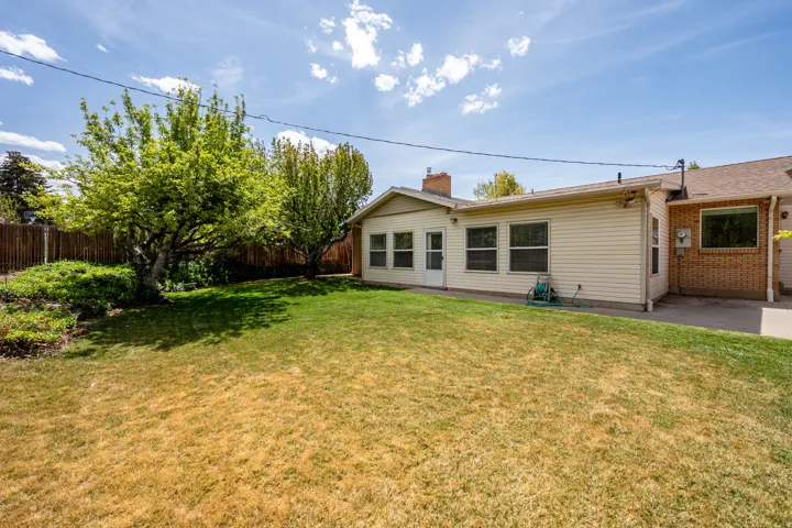 Rear view of property with a fenced backyard and a chimney