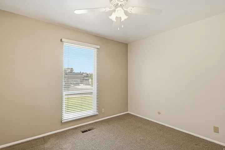 Carpeted empty room with baseboards and ceiling fan