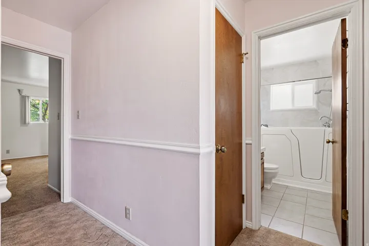 Full bathroom with toilet and light colored carpet