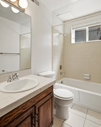 Bathroom with vanity, shower / washtub combination, and light tile patterned floors