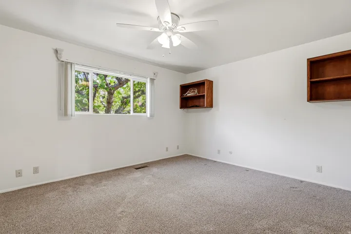 Spare room featuring a ceiling fan and carpet