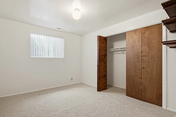 Unfurnished bedroom featuring a closet and light carpet