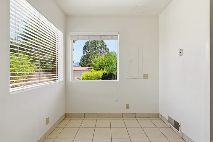 Empty room with electric panel and light tile patterned floors