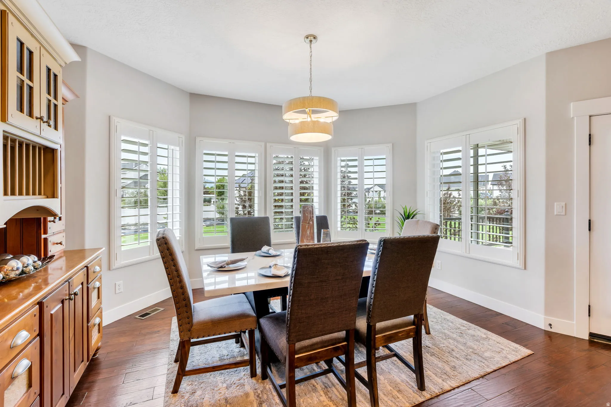 Dining area featuring wood-finish flooring, a contemporary chandelier, and a built-in hutch