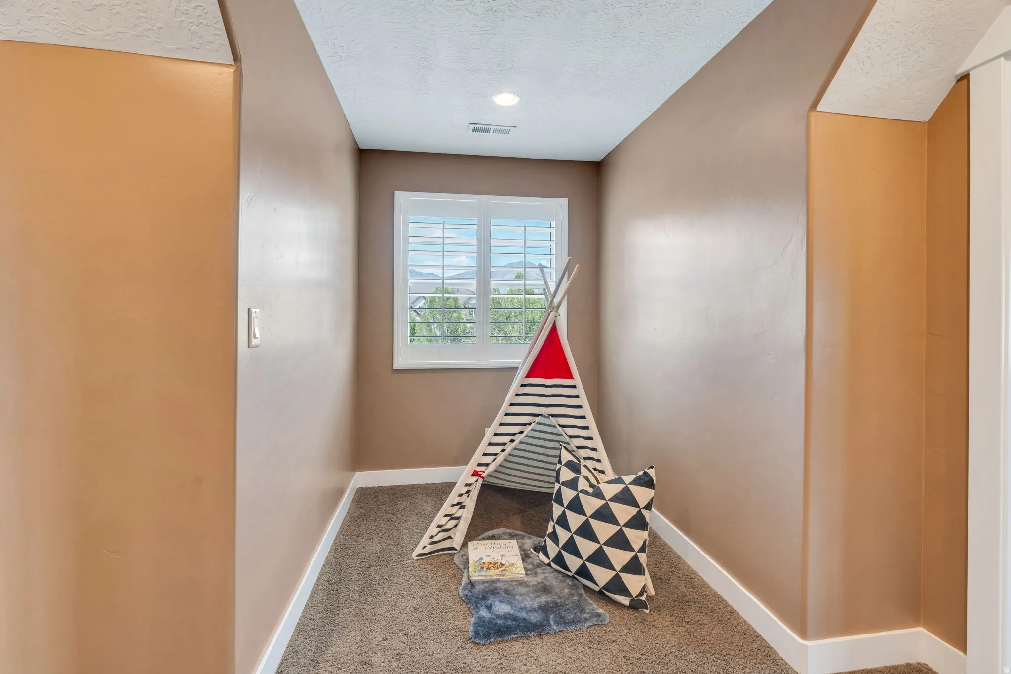 Recreation room featuring a textured ceiling and carpet