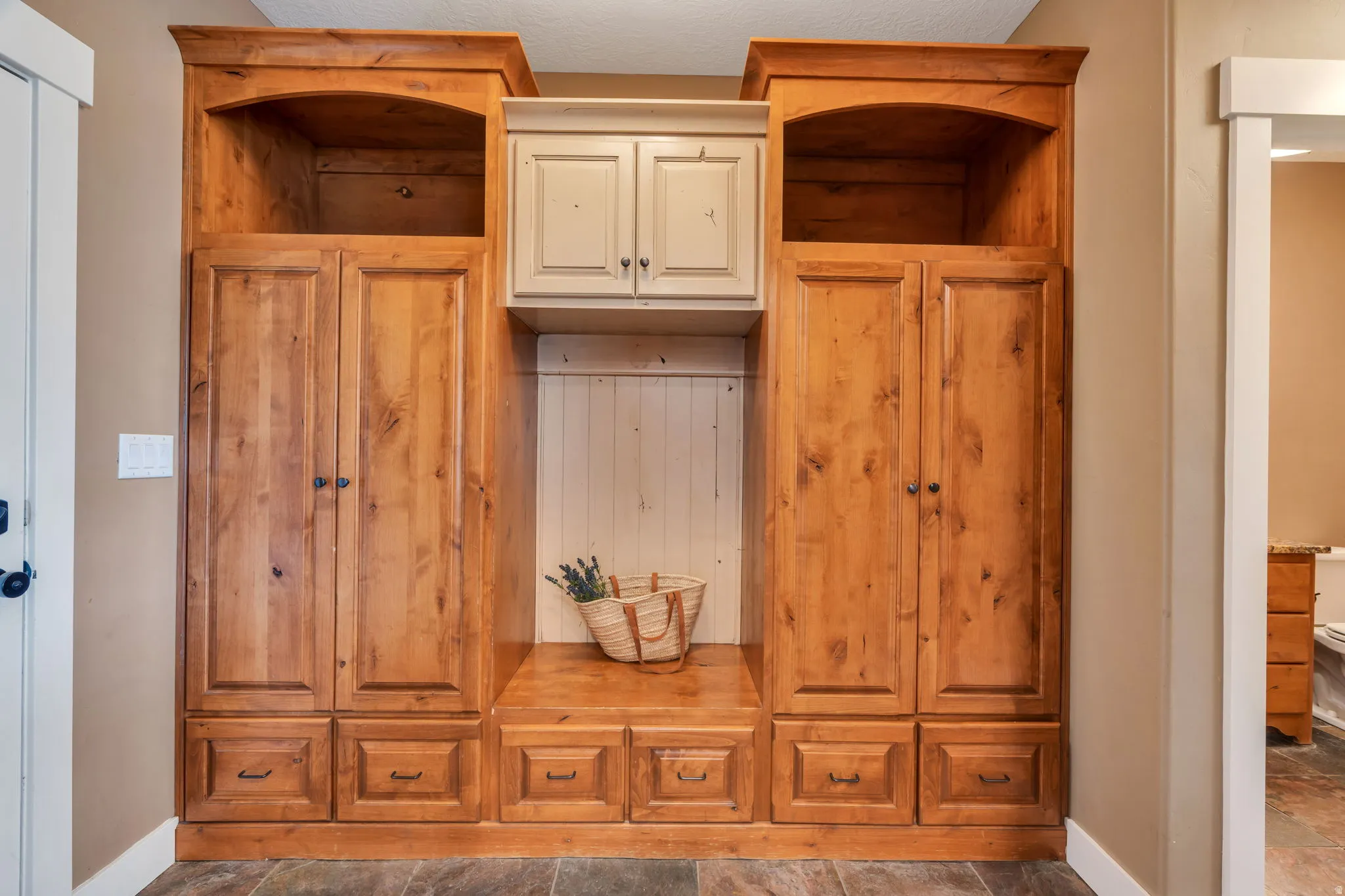 Mudroom featuring baseboards and dark stone finish flooring