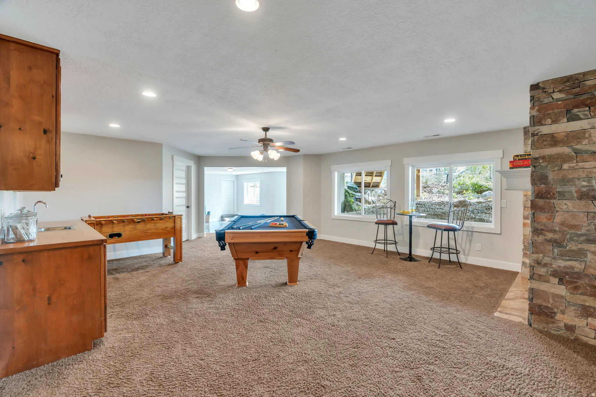 Playroom featuring light carpet, pool table, recessed lighting, ceiling fan, and a textured ceiling