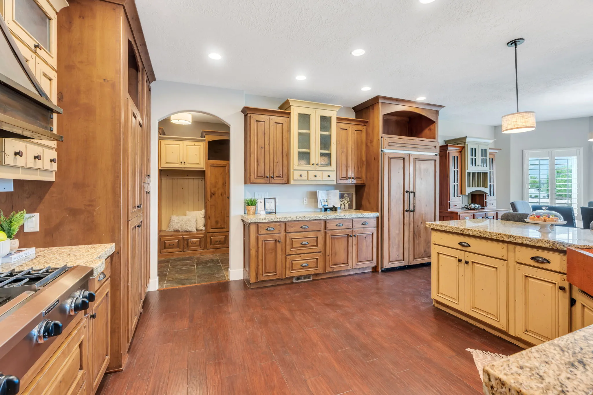 Spacious kitchen featuring rich wood-finish flooring, granite countertops, and recessed lighting