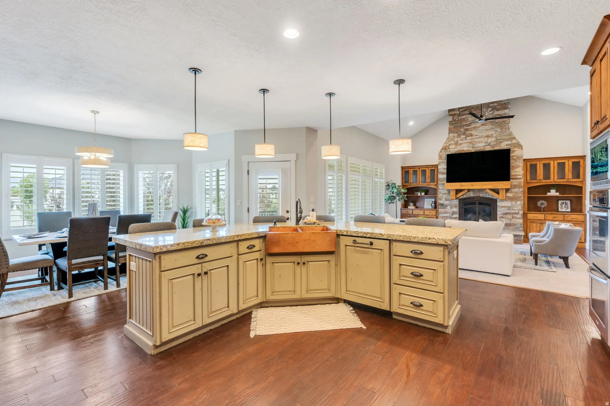 Expansive kitchen island with granite countertops and an integrated copper farmhouse sink