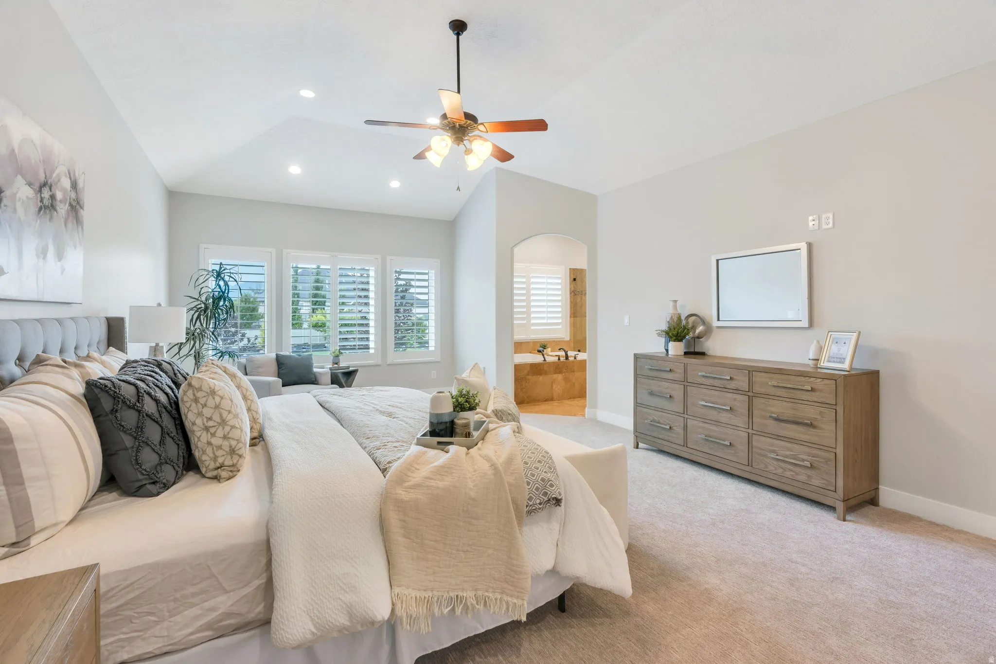 Vaulted ceiling with recessed lighting and a ceiling fan