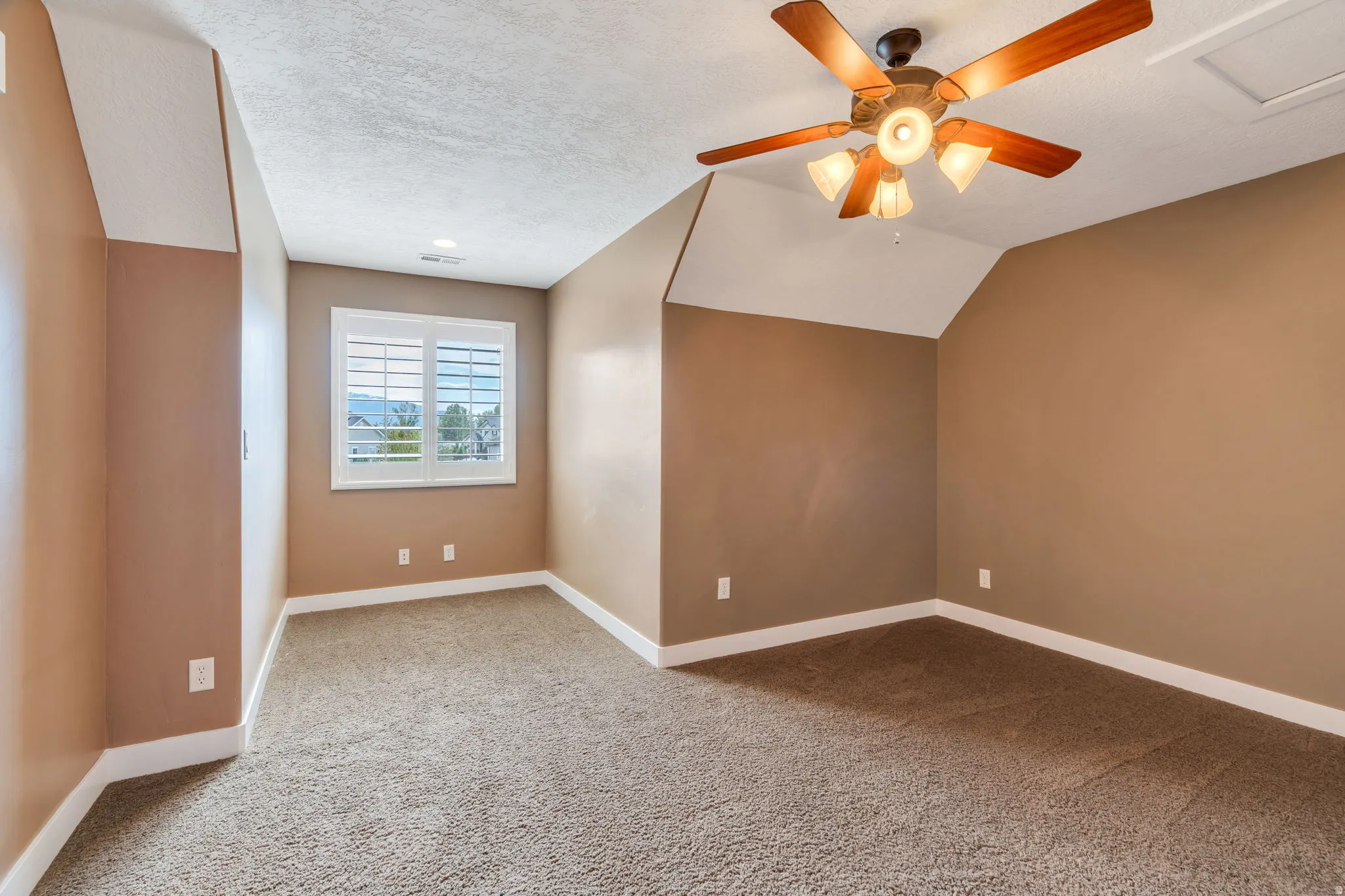 Bonus room featuring light carpet and a ceiling fan