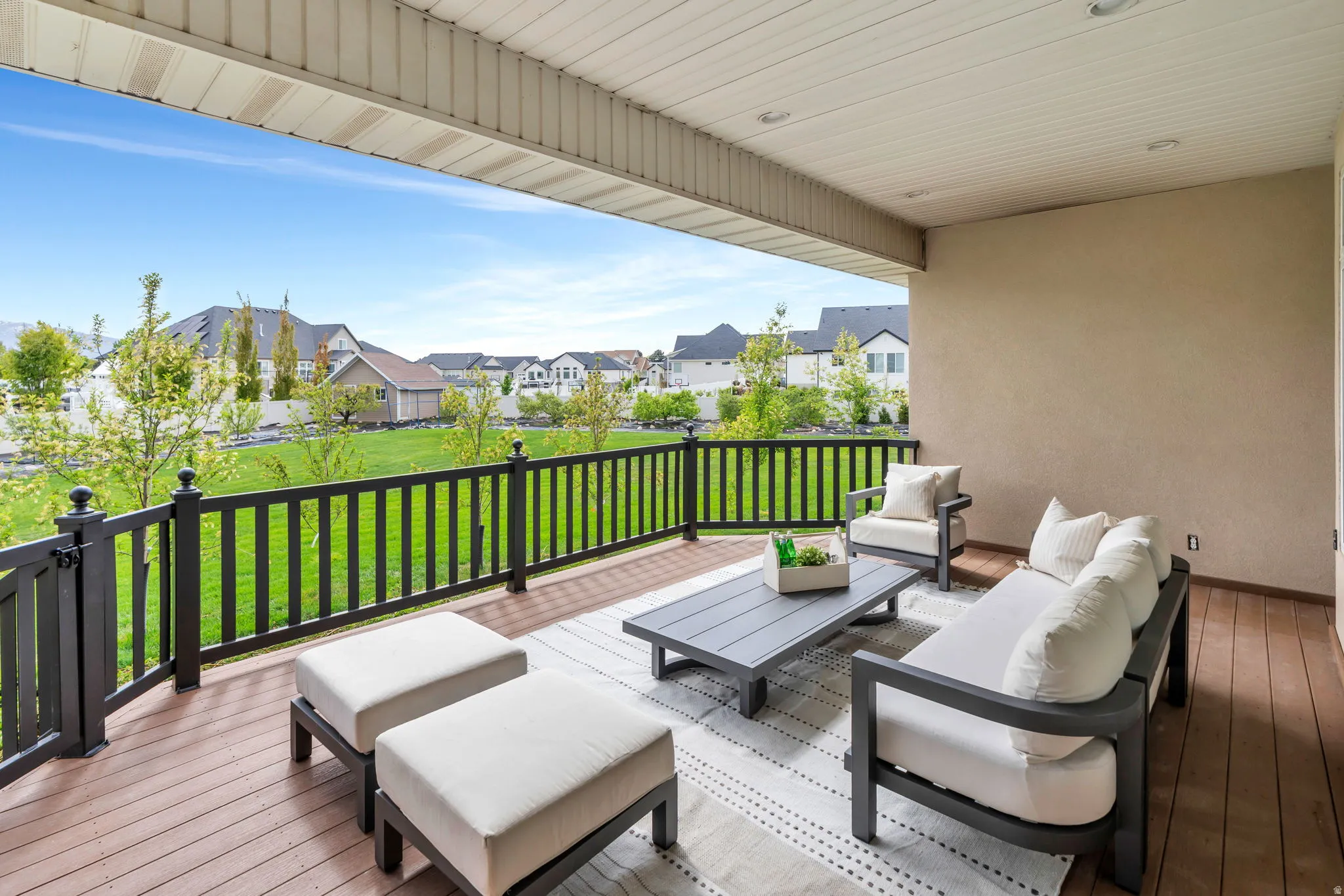 Wooden deck featuring outdoor seating, a lawn, and a residential view