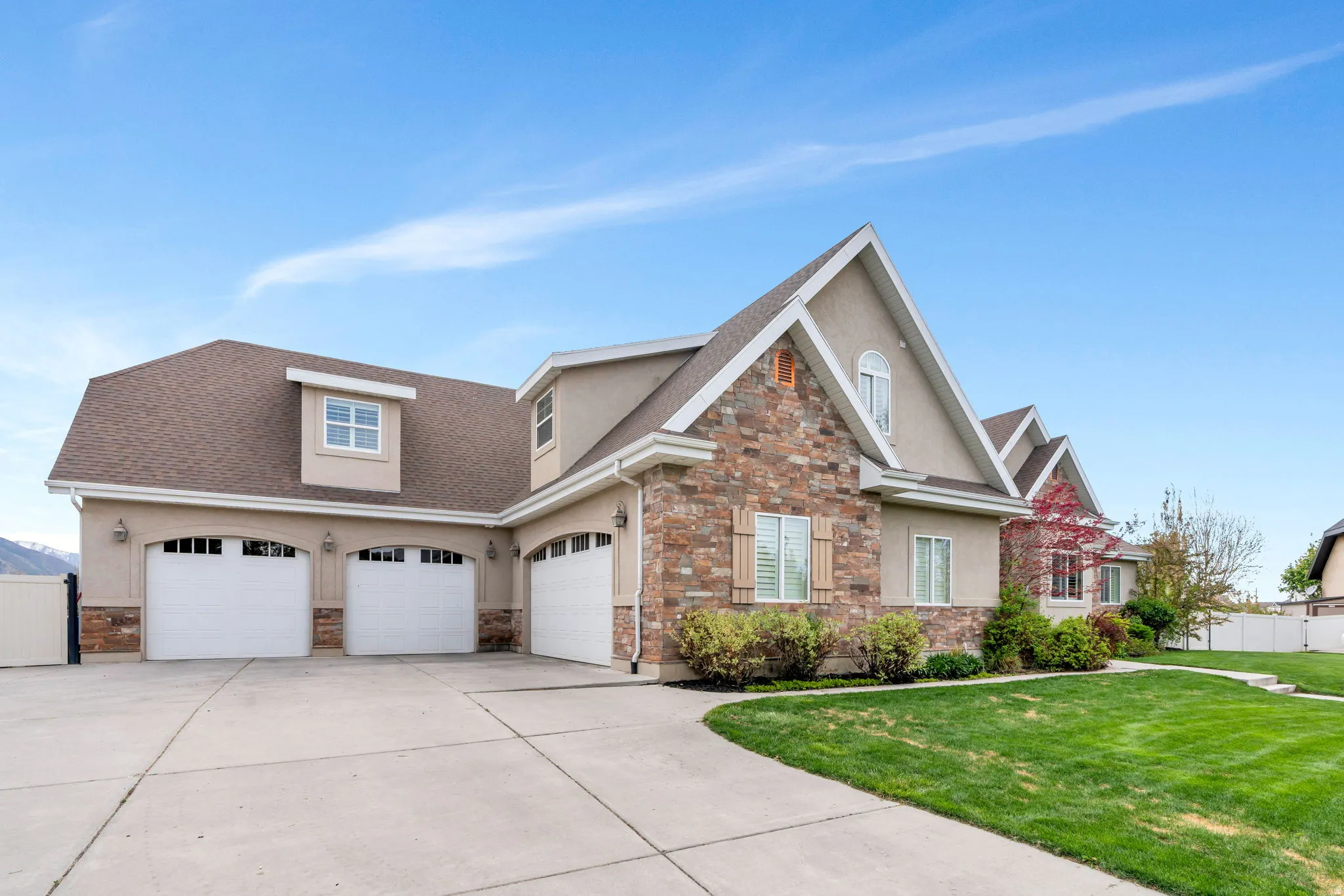 View of front of house featuring stucco siding, stone siding, and a shingled roof