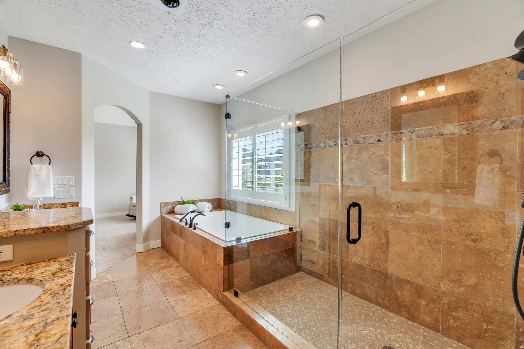 Full bath with vanity, a bath, a textured ceiling, a stall shower, and recessed lighting