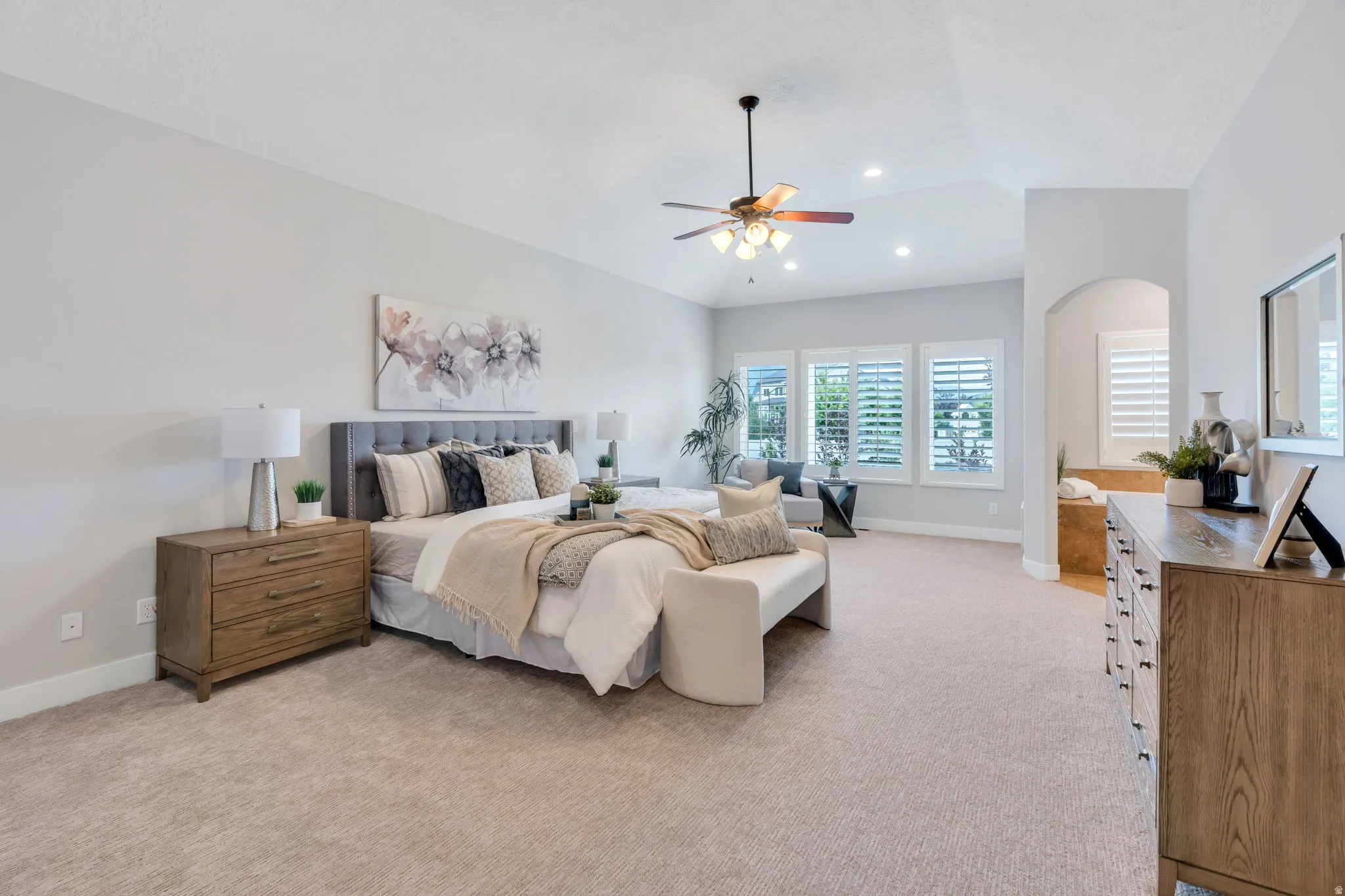 Spacious room featuring vaulted ceilings, recessed lighting, and a ceiling fan