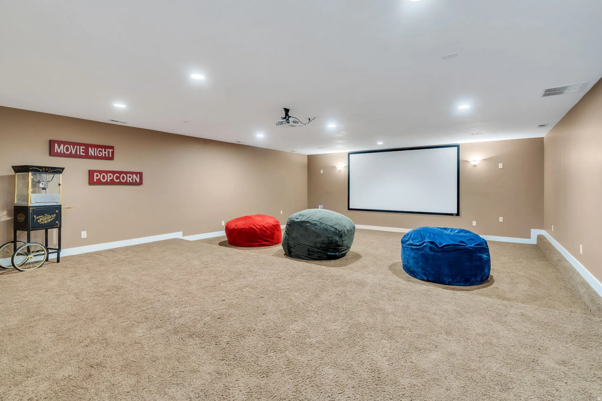 Home theater room with light colored carpet and recessed lighting