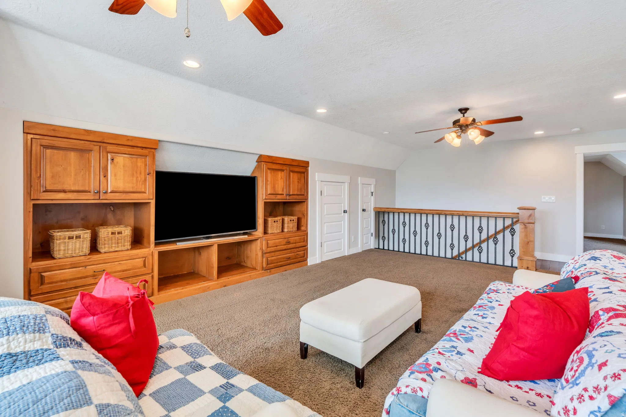 Carpeted living area with ceiling fan, vaulted ceiling, and recessed lighting