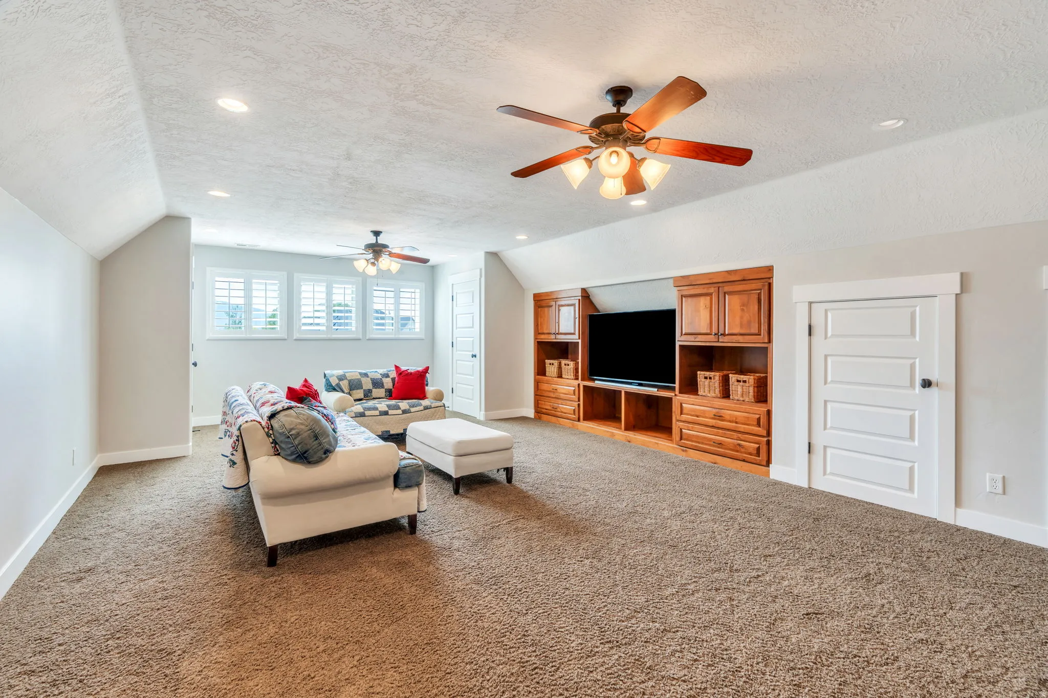 Carpeted recreation room featuring an entertainment center with wood cabinetry, recessed lighting, and a ceiling fan