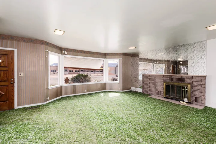 Unfurnished living room with carpet floors and a fireplace