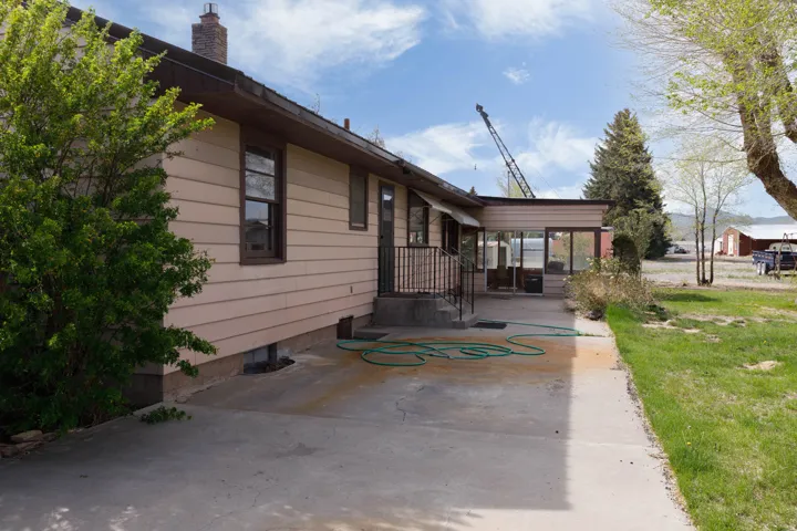 View of side of home with a lawn and a sunroom