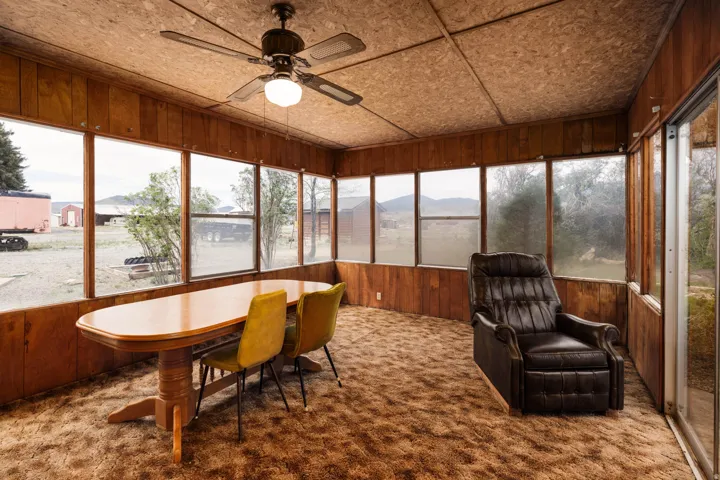 Sunroom / solarium with wood walls, carpet, plenty of natural light, and a mountain view