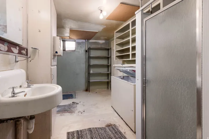 Full bathroom featuring unfinished concrete floors, a stall shower, and a closet