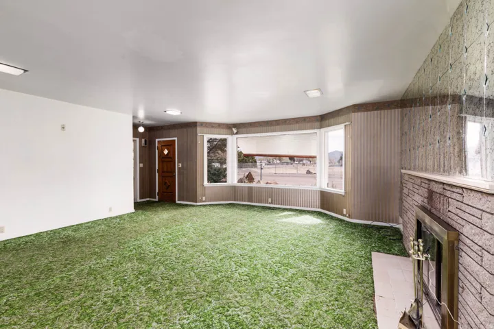 Unfurnished living room featuring light colored carpet and a fireplace
