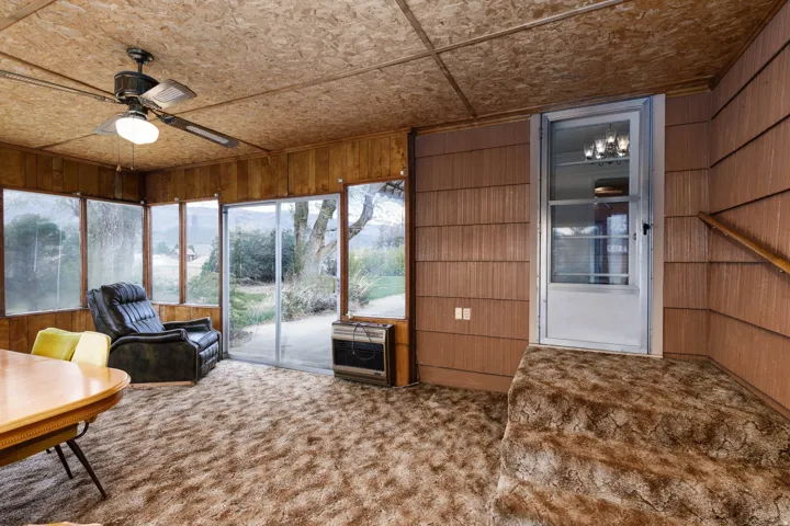 Sunroom / solarium with carpet floors, wooden walls, and heating unit