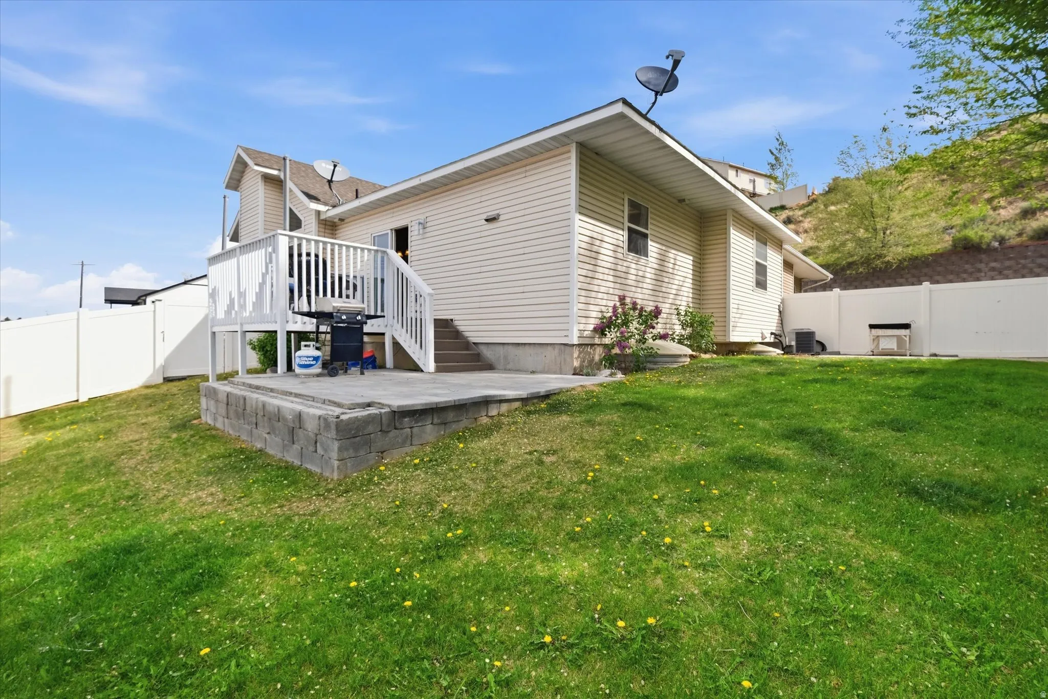Rear view of house with a fenced backyard and a deck