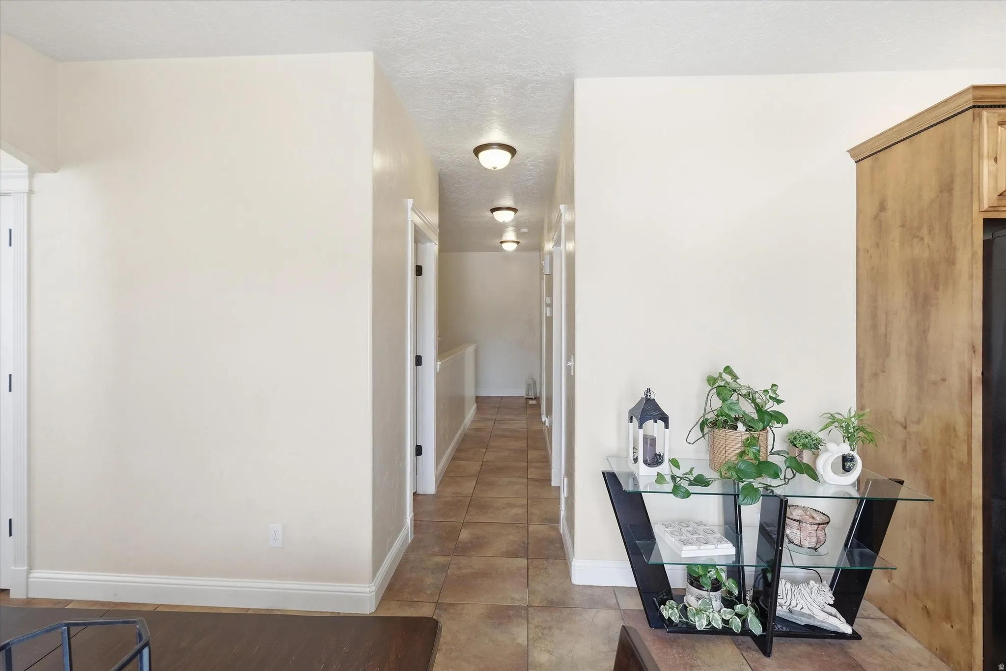 Hall with baseboards and a textured ceiling