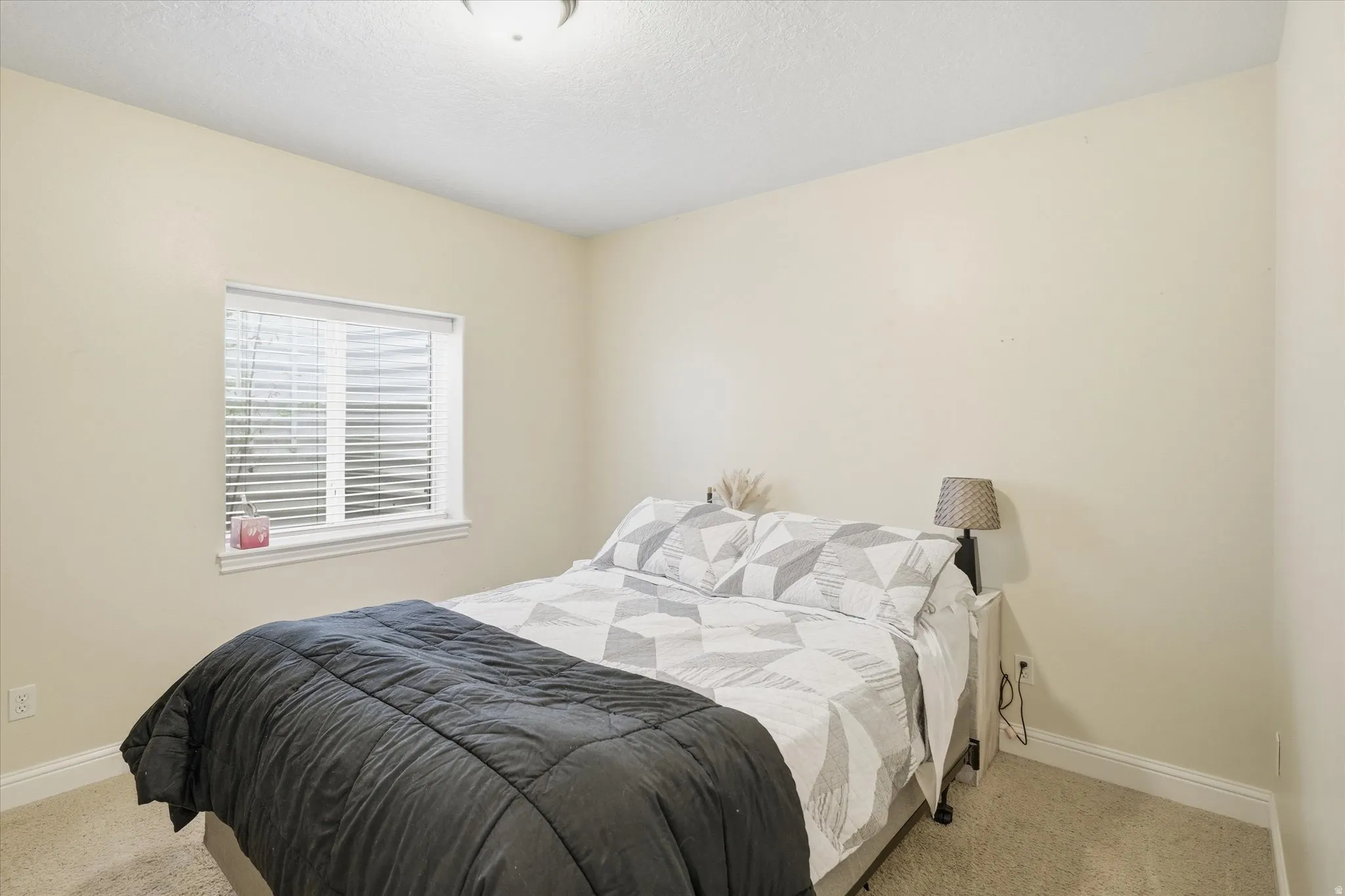 Bedroom featuring carpet floors and a textured ceiling