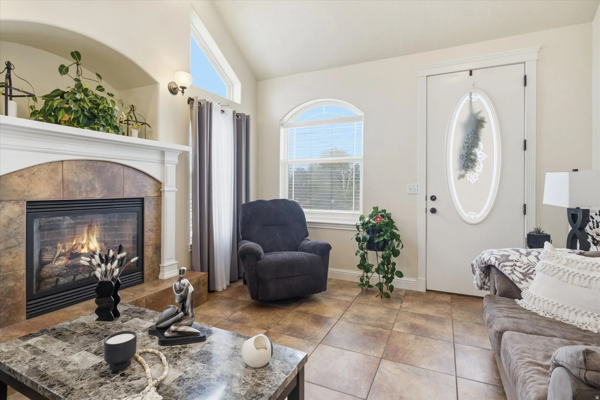 Living area featuring vaulted ceiling and a tile fireplace