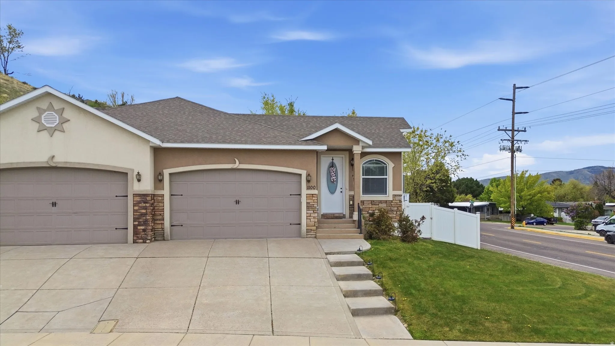 View of front of home with stone siding, roof with shingles, a garage, driveway, and stucco siding