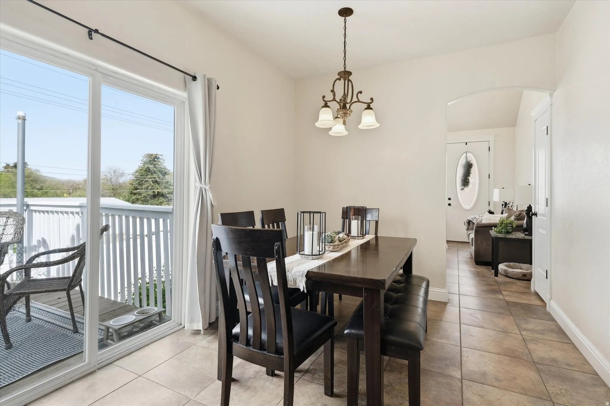 Dining area featuring arched walkways, light tile patterned flooring, and hanging lights