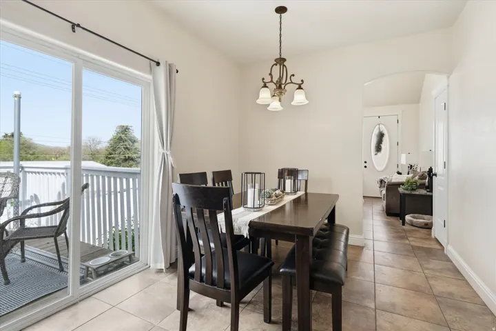 Dining area featuring arched walkways, light tile patterned flooring, and hanging lights