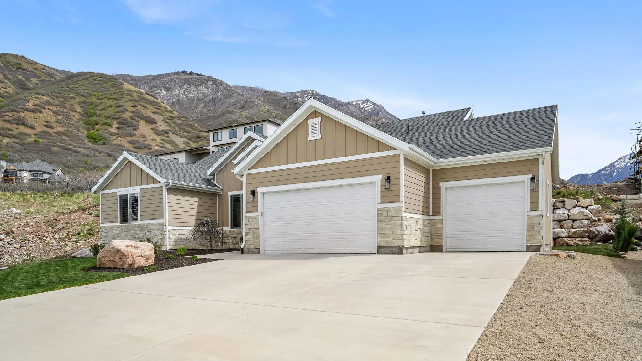 Craftsman-style home featuring board and batten siding, stone siding, a mountain view, and a 3-car garage