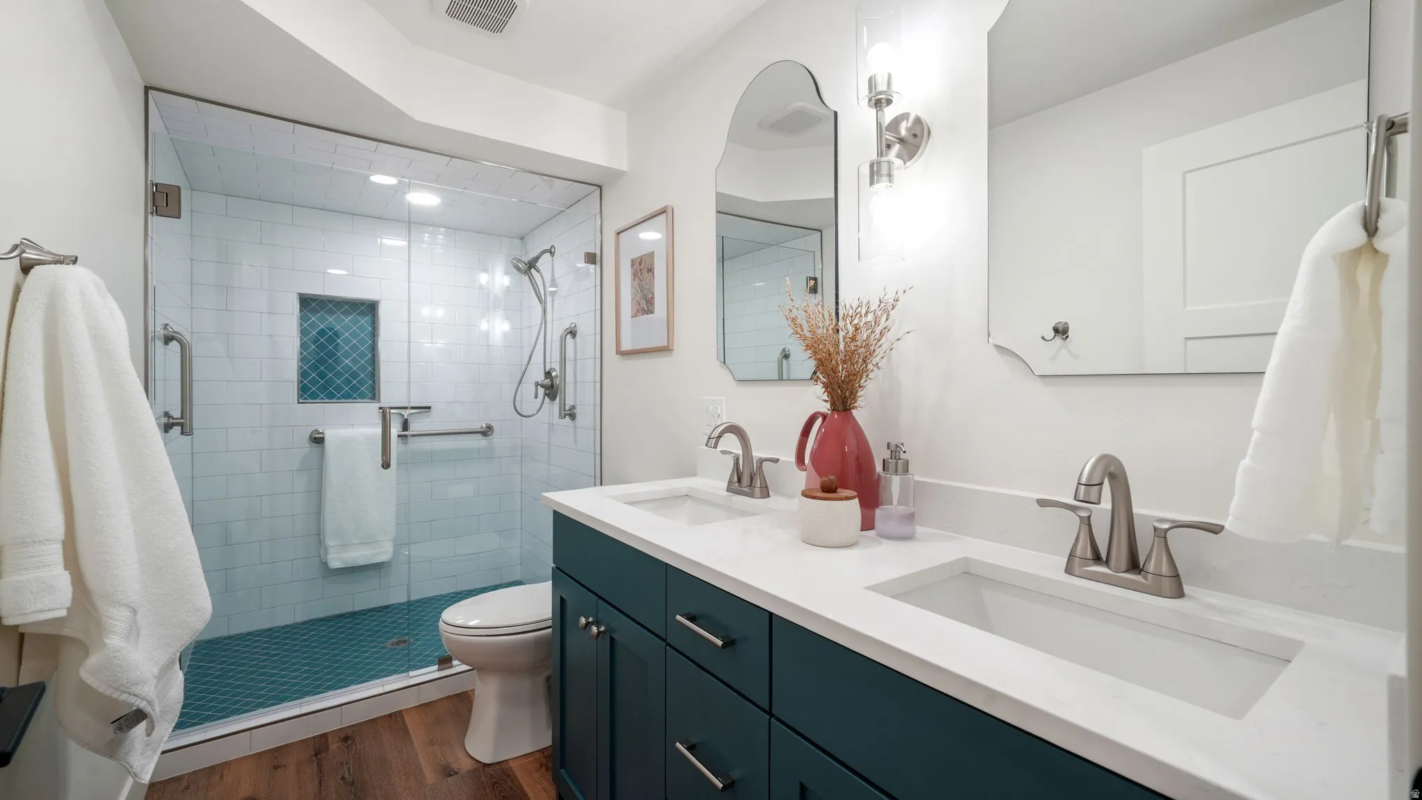 3/4 bath featuring double vanity, a stall shower, wood-style LVP floors, and recessed lighting