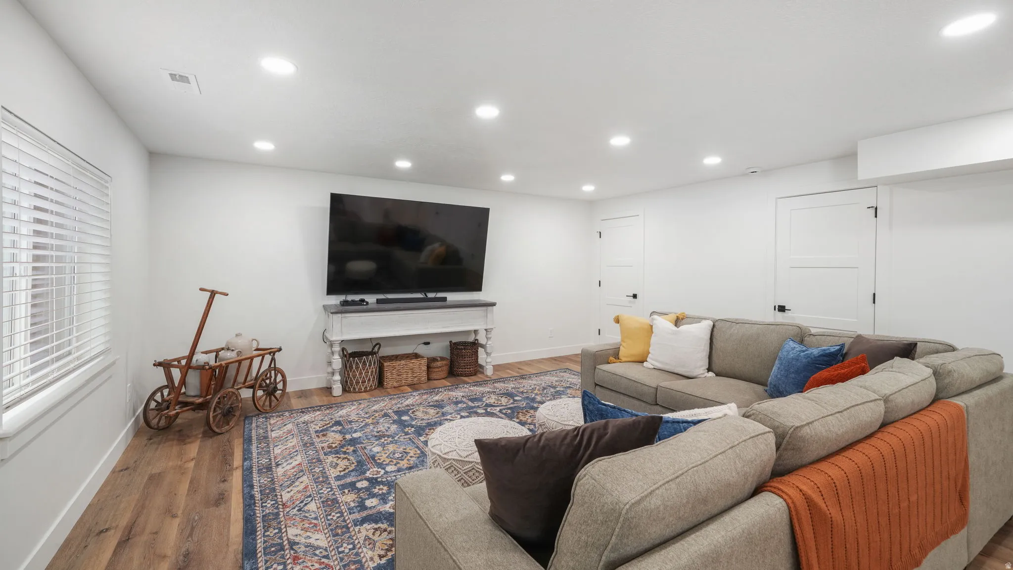 Living area with LVP floors, recessed lighting, storage, and powder room access.