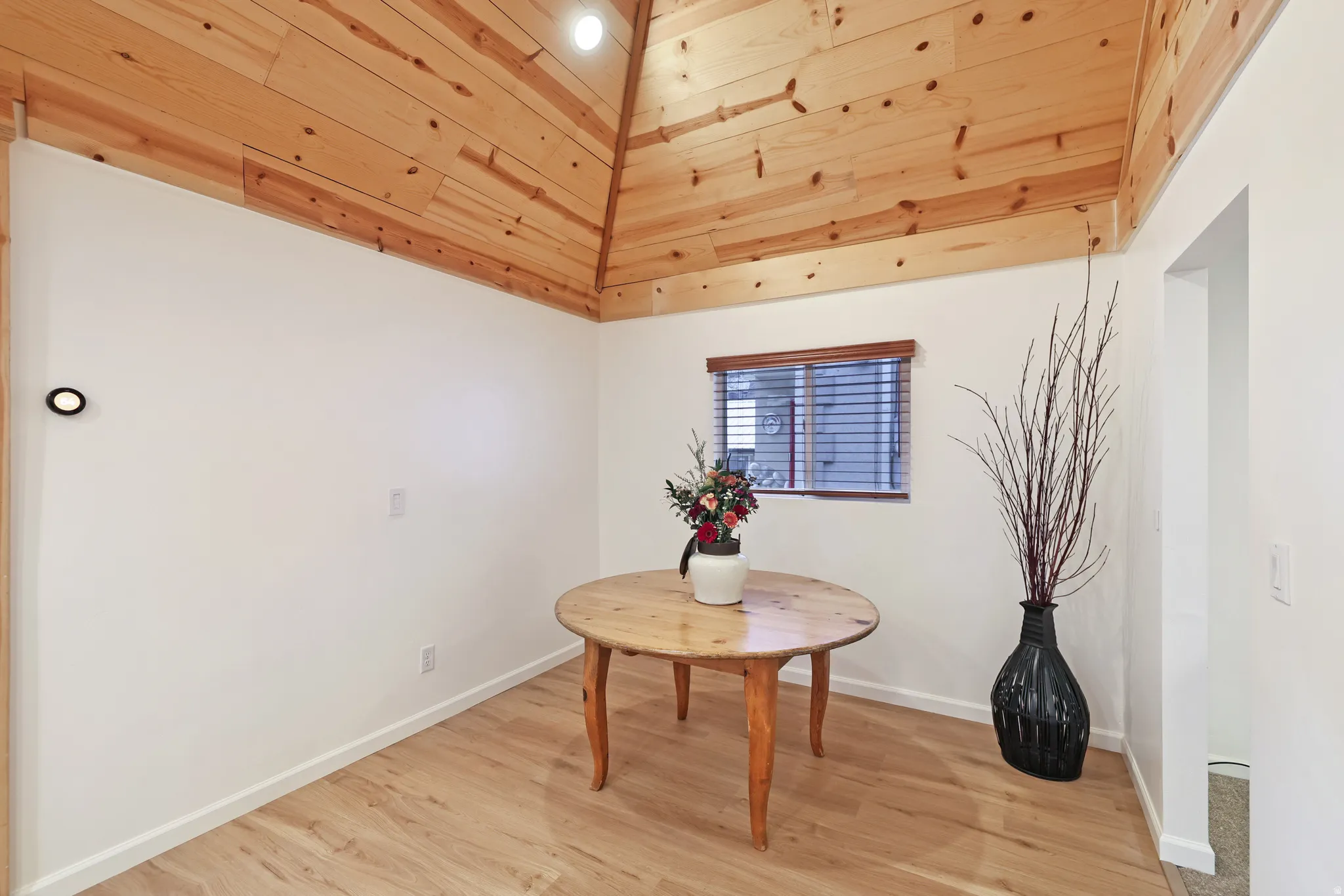 Dining room with light wood-type flooring and wooden ceiling