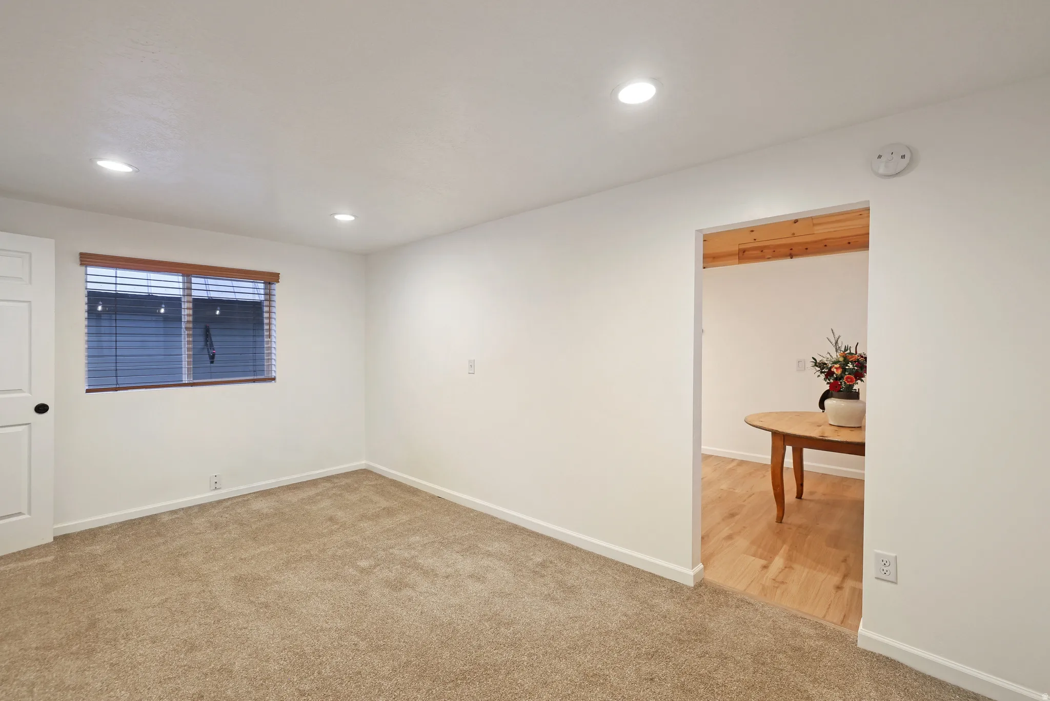 Empty room with light colored carpet, recessed lighting, and a smoke detector