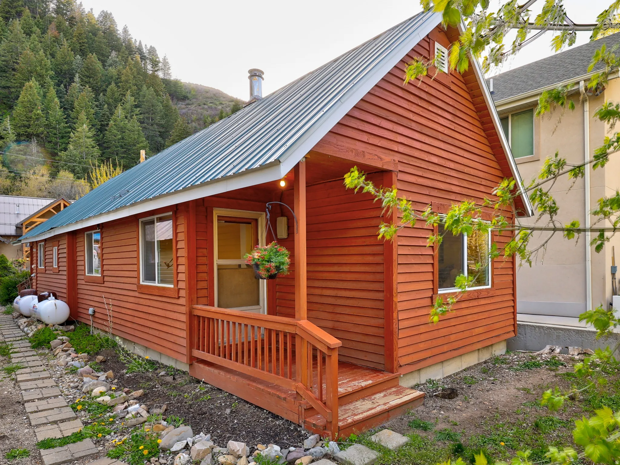 View of side of home featuring a metal roof and a garage