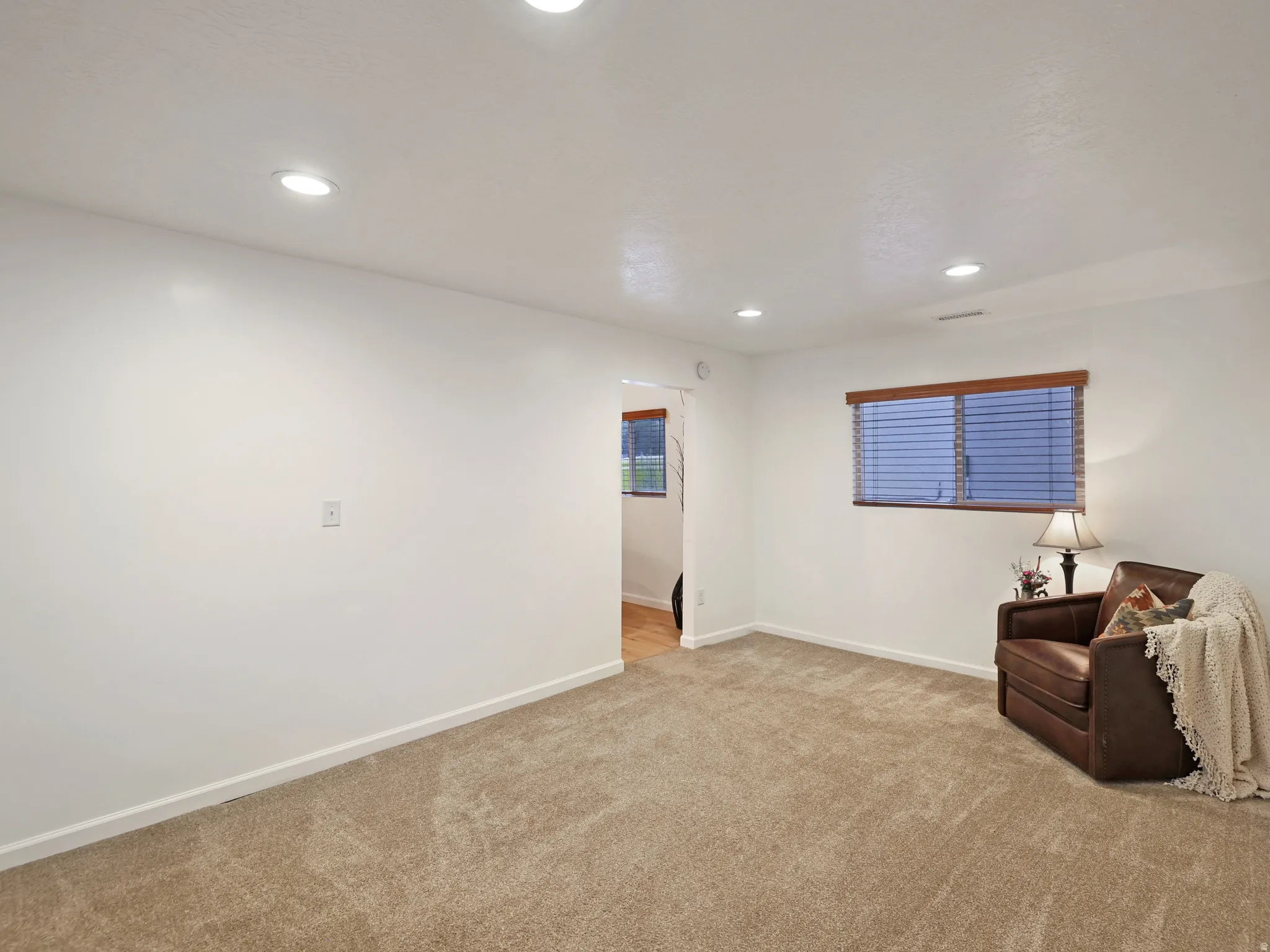Living area with recessed lighting and light colored carpet