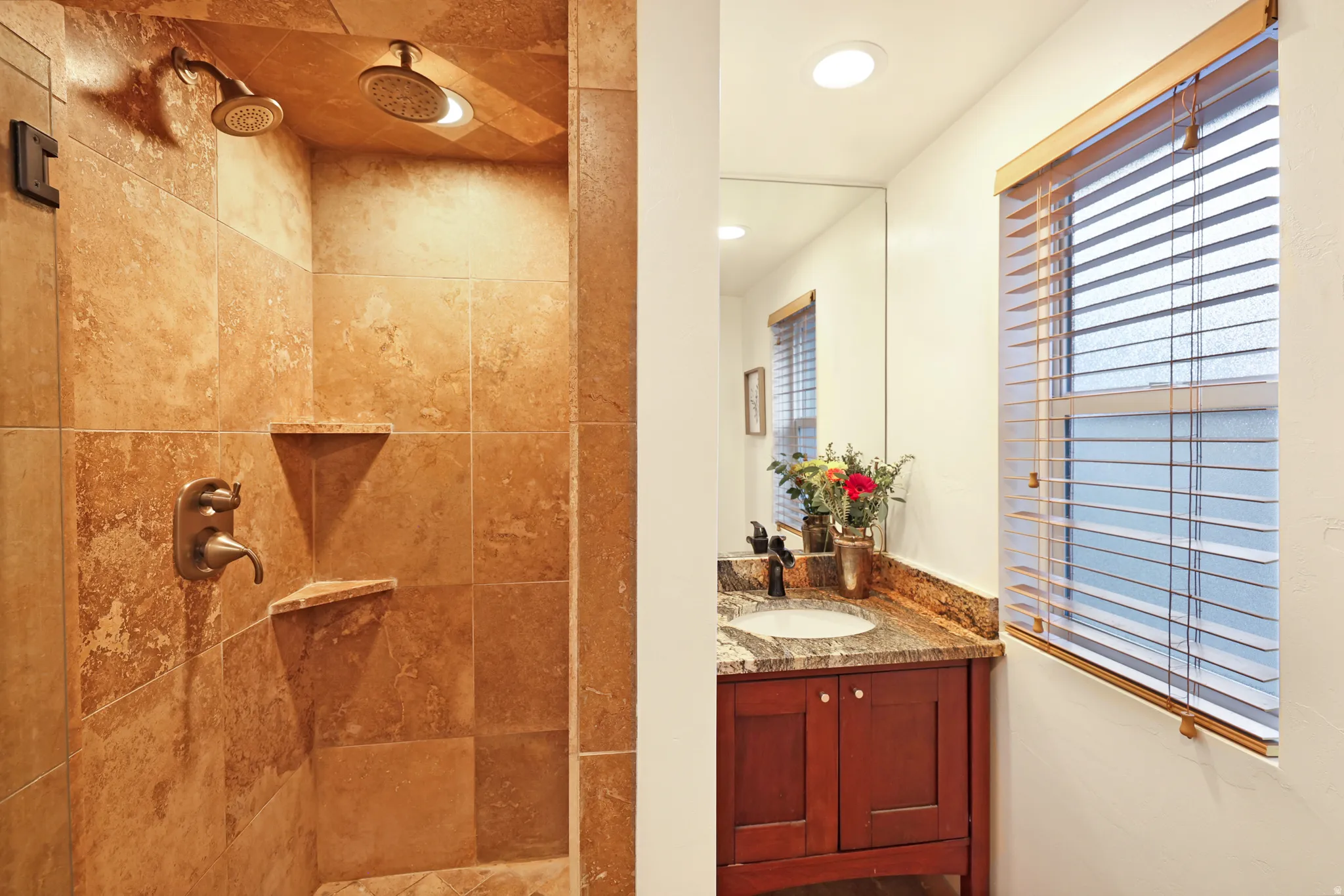 Bathroom featuring vanity, a tile shower, and recessed lighting