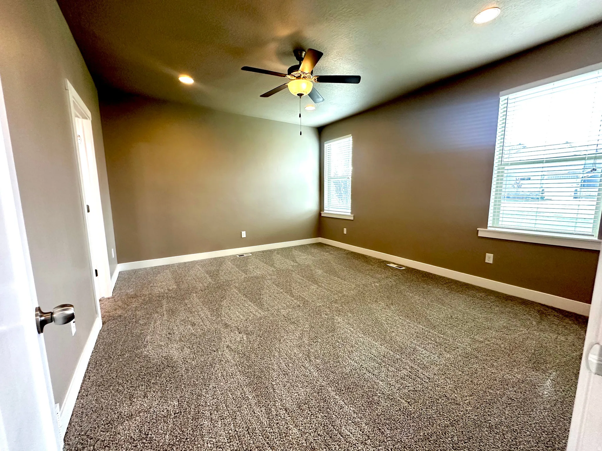 Carpeted empty room featuring a ceiling fan and recessed lighting