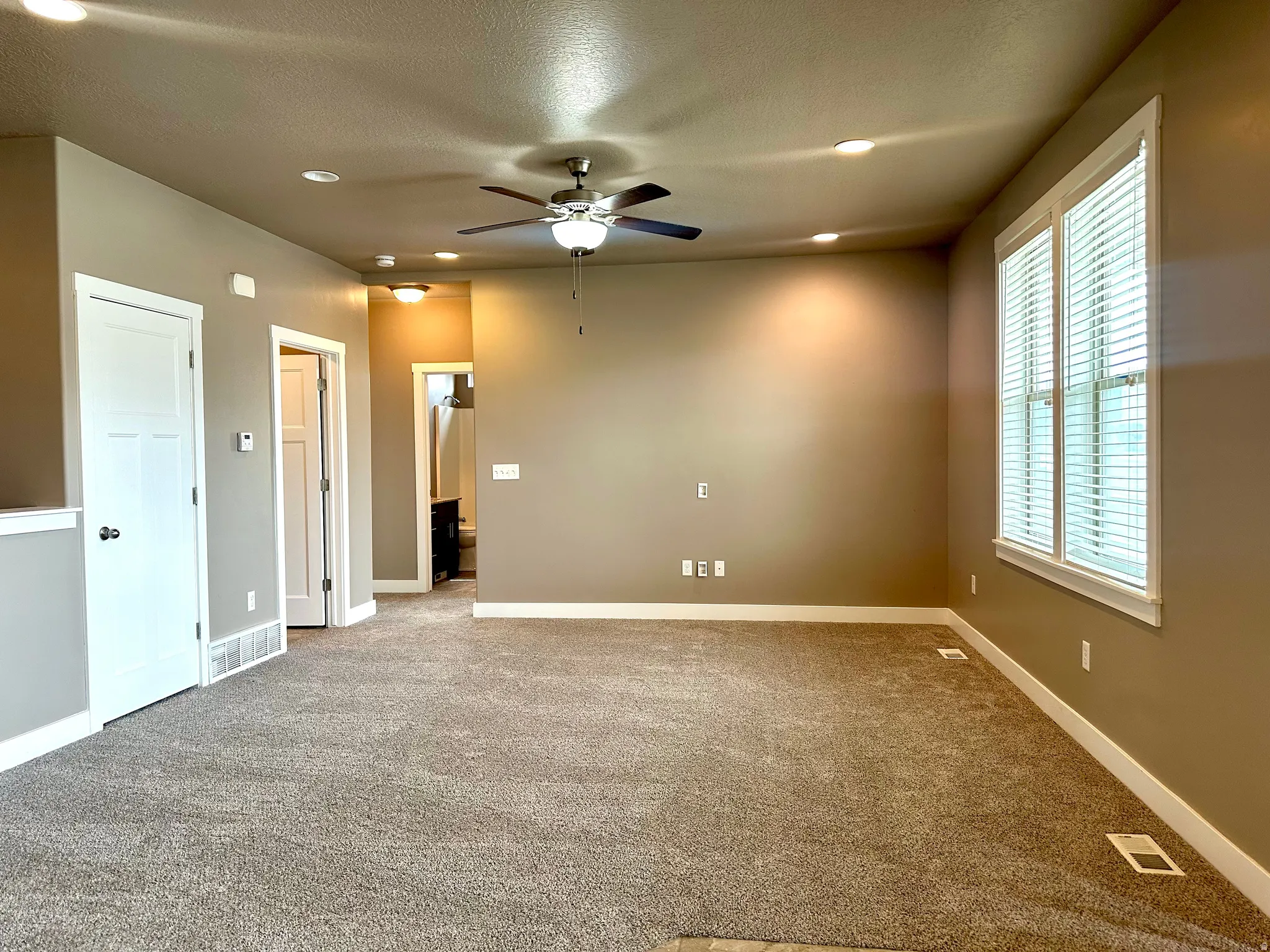 Carpeted empty room with a ceiling fan, recessed lighting, and a textured ceiling