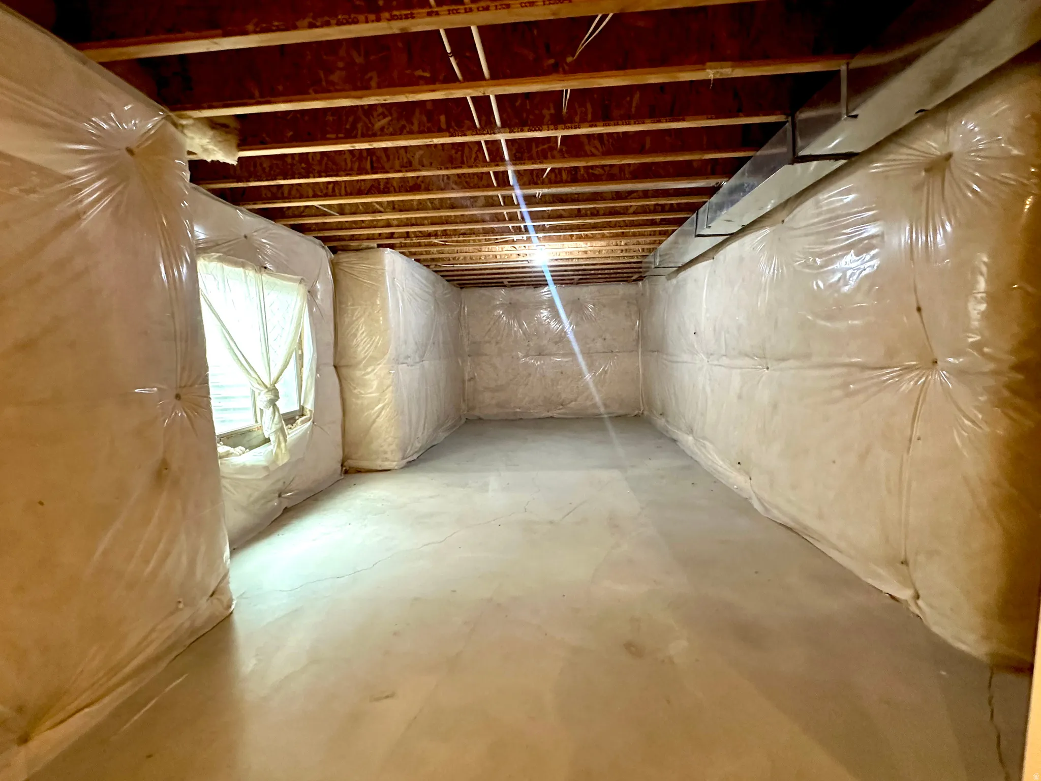 Unfinished Basement Living room, carpet, studs & drywall remaining to finish.