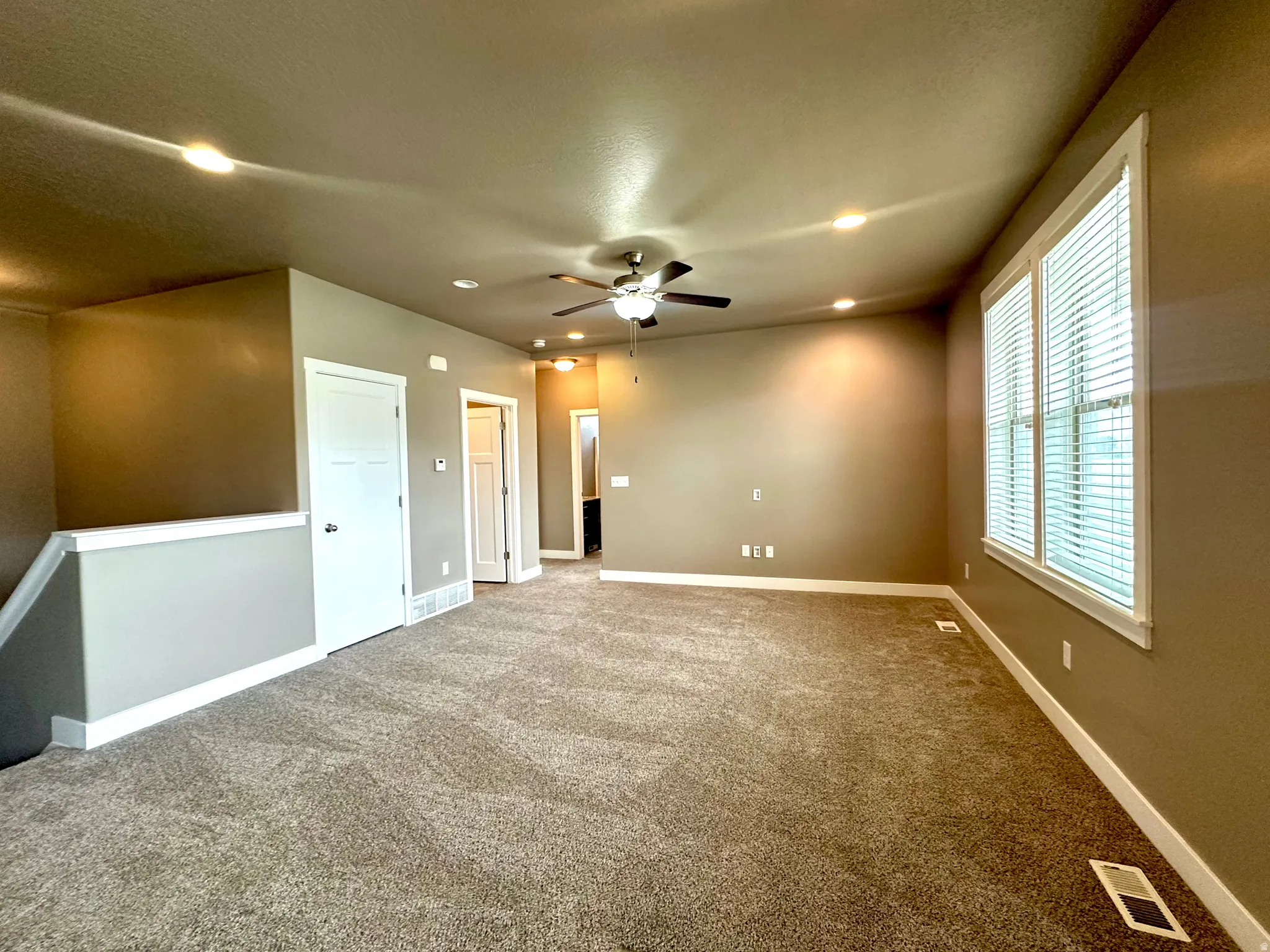 Carpeted spare room with ceiling fan and recessed lighting